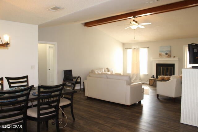 dining space with lofted ceiling with beams, ceiling fan, and dark wood-type flooring