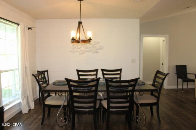 dining area with lofted ceiling, dark hardwood / wood-style floors, and a chandelier