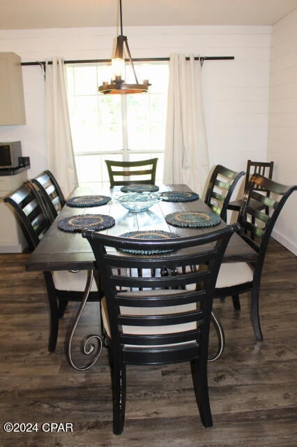 dining area with a notable chandelier and dark wood-type flooring