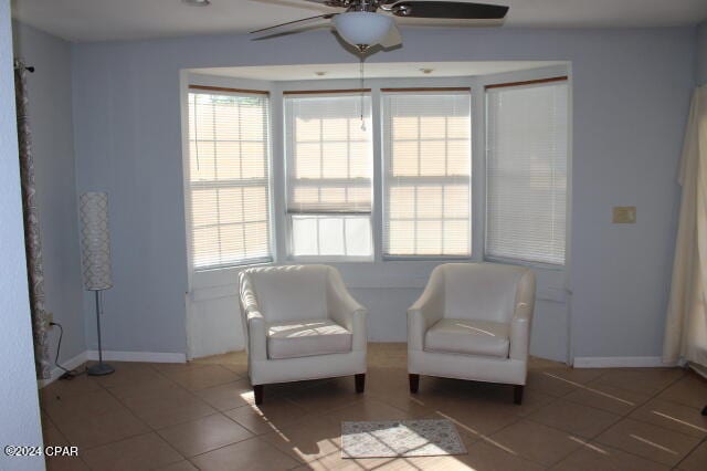 living area featuring tile patterned floors, ceiling fan, and a healthy amount of sunlight