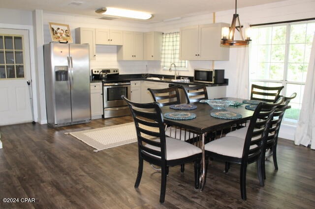 dining room with an inviting chandelier, dark hardwood / wood-style floors, and sink