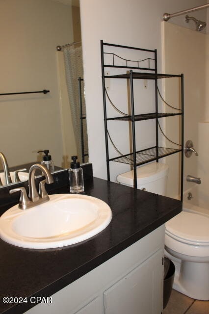 full bathroom with tile patterned floors, shower / bath combo, vanity, and toilet