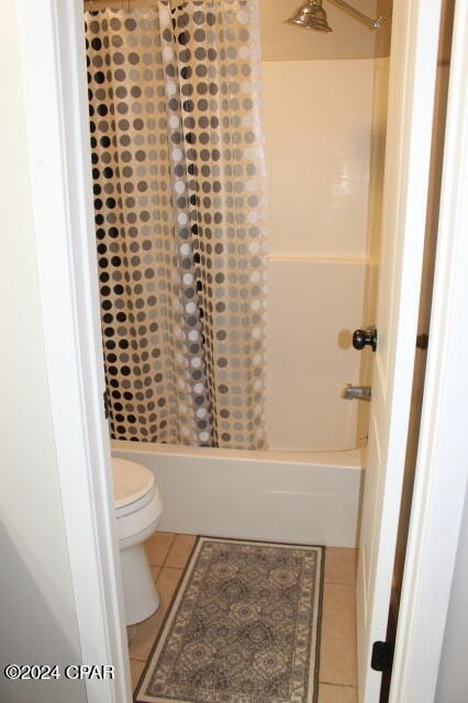 bathroom featuring tile patterned flooring, toilet, and shower / bath combo with shower curtain