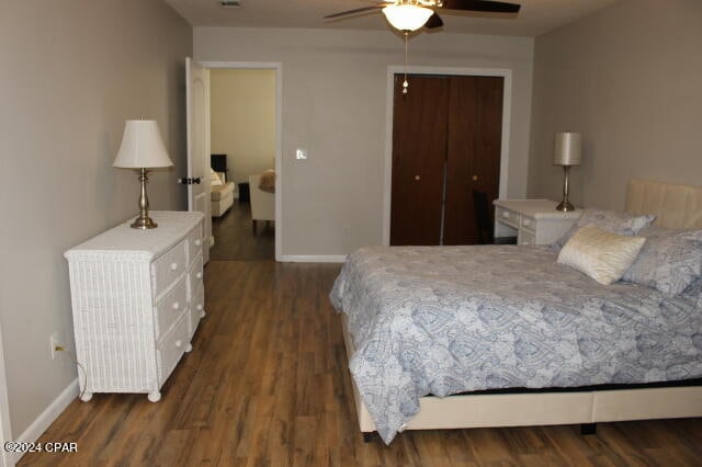 bedroom featuring dark hardwood / wood-style flooring, ceiling fan, and a closet