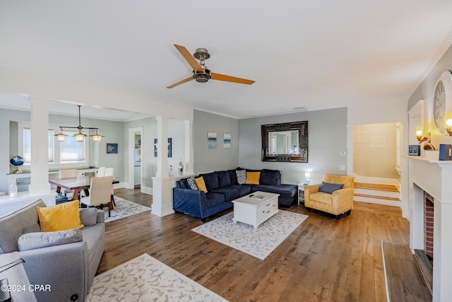 living room featuring ceiling fan, dark hardwood / wood-style floors, a fireplace, and crown molding