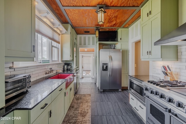 kitchen featuring tasteful backsplash, green cabinetry, wall chimney exhaust hood, appliances with stainless steel finishes, and wooden ceiling