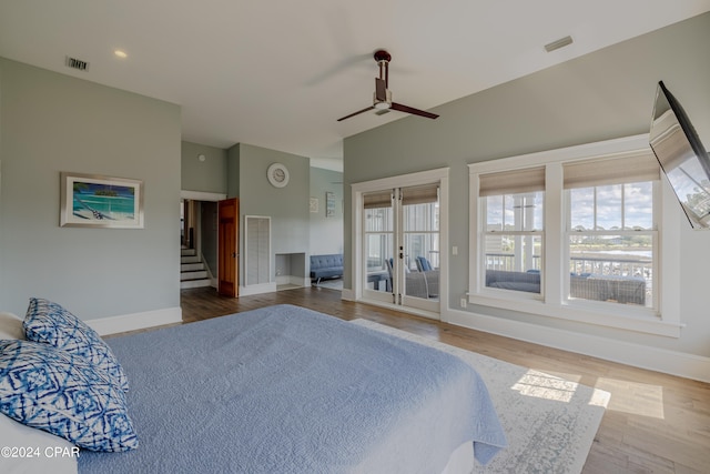 bedroom featuring ceiling fan, hardwood / wood-style flooring, access to outside, and multiple windows