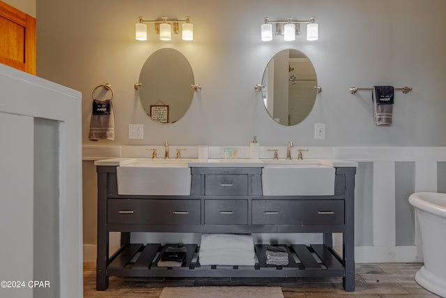 bathroom featuring vanity, a washtub, and hardwood / wood-style flooring