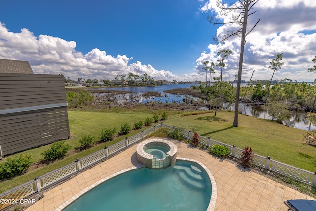 view of swimming pool featuring a yard, an in ground hot tub, a water view, and a patio area