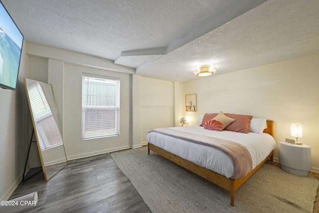 bedroom with dark hardwood / wood-style flooring and a textured ceiling