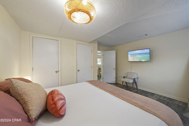 bedroom featuring dark wood-type flooring and a textured ceiling