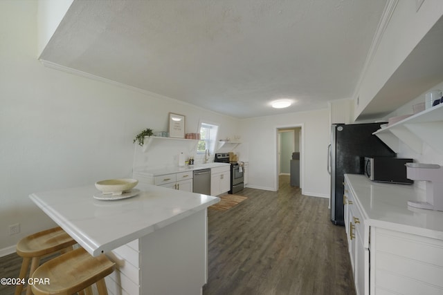 kitchen with dark wood-type flooring, kitchen peninsula, a breakfast bar area, white cabinets, and appliances with stainless steel finishes