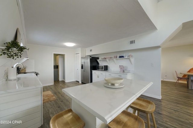 kitchen featuring white cabinets, a kitchen breakfast bar, sink, and appliances with stainless steel finishes