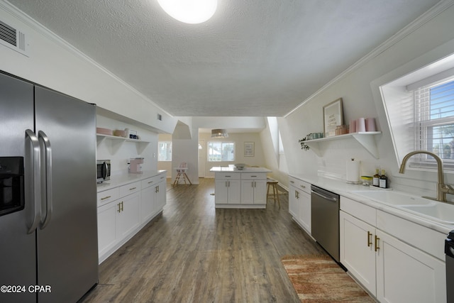 kitchen with sink, dark hardwood / wood-style floors, appliances with stainless steel finishes, white cabinets, and ornamental molding