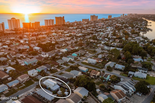 aerial view at dusk featuring a water view