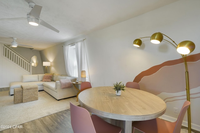 dining area featuring wood-type flooring and ceiling fan