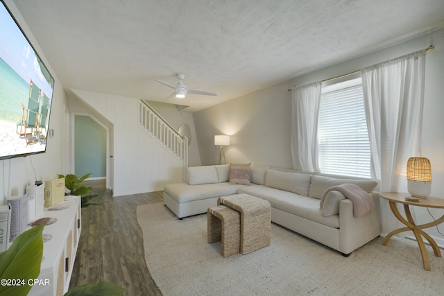 living room featuring ceiling fan, wood-type flooring, and a textured ceiling