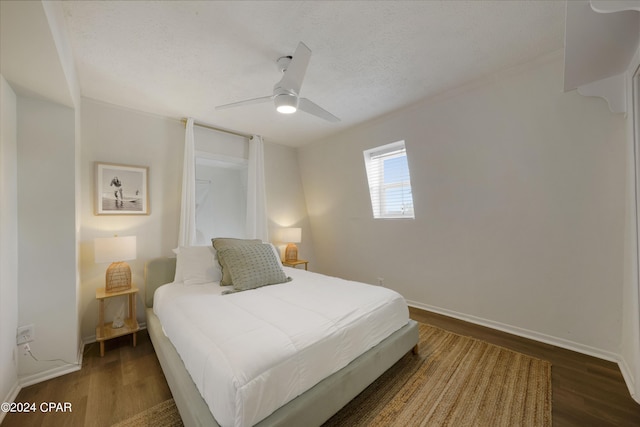 bedroom featuring a textured ceiling, dark hardwood / wood-style floors, and ceiling fan