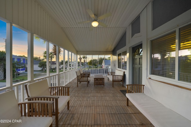 sunroom with ceiling fan and lofted ceiling