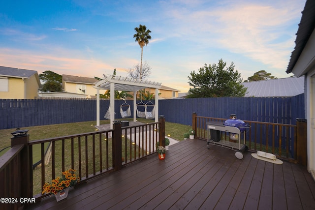 deck at dusk with a lawn and a pergola