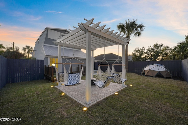 patio terrace at dusk with a pergola and a yard