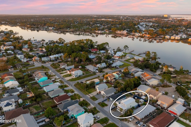 aerial view at dusk featuring a water view