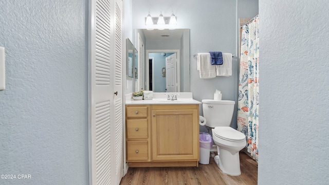 bathroom with wood-type flooring, vanity, and toilet