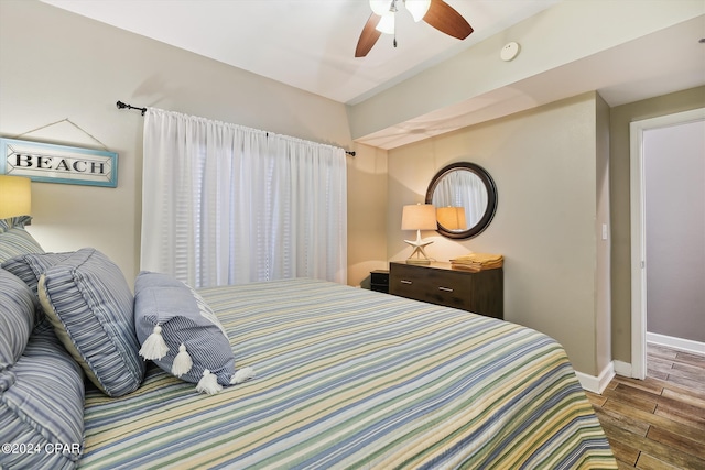 bedroom with wood finish floors, a ceiling fan, and baseboards