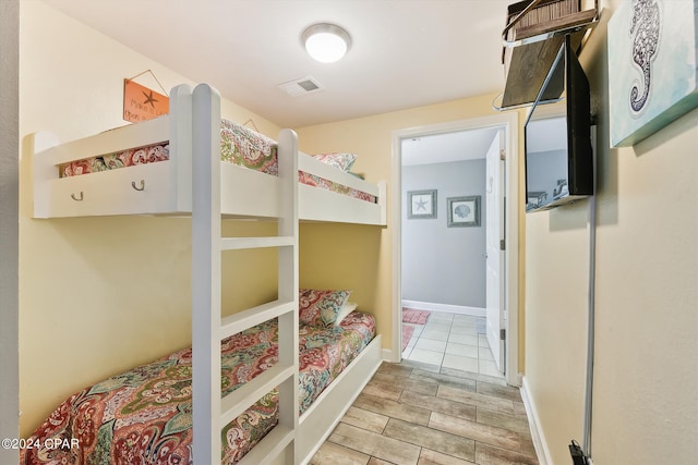 bedroom with baseboards, visible vents, and wood tiled floor