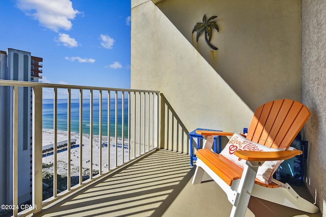 balcony featuring a view of the beach and a water view