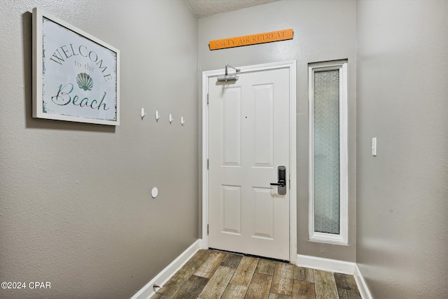 entryway featuring baseboards and wood finished floors