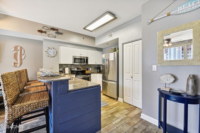 living room featuring ceiling fan, light hardwood / wood-style floors, and rail lighting