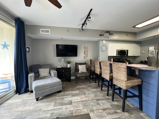 interior space with ceiling fan, visible vents, and baseboards