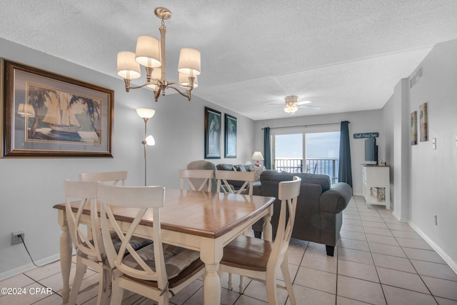 dining room with light tile patterned flooring, ceiling fan with notable chandelier, and a textured ceiling