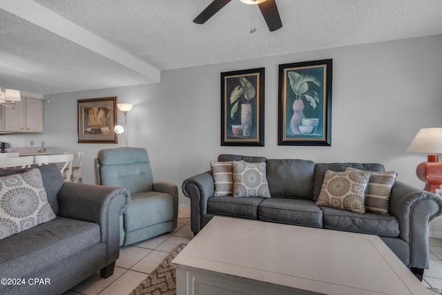 living room with a textured ceiling, light tile patterned flooring, and ceiling fan