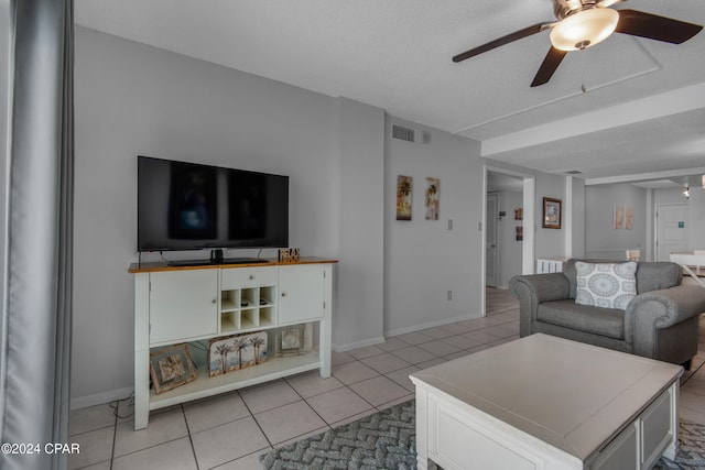 tiled living room featuring a textured ceiling and ceiling fan