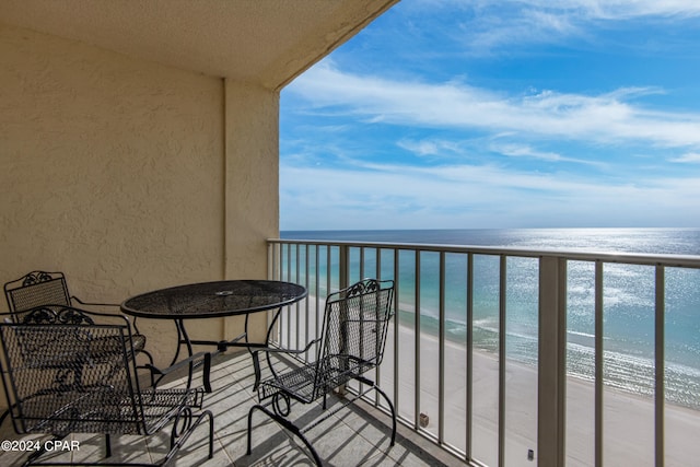 balcony featuring a water view and a view of the beach