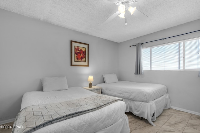 bedroom with ceiling fan and a textured ceiling