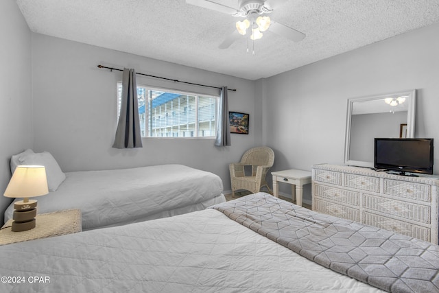 bedroom with ceiling fan and a textured ceiling