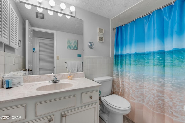 bathroom featuring tile walls, a textured ceiling, vanity, and toilet