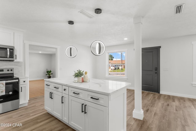 kitchen with white cabinetry, appliances with stainless steel finishes, and pendant lighting