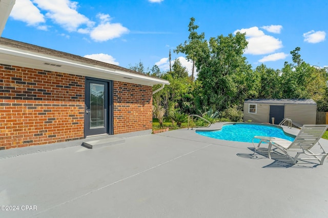 view of swimming pool featuring a storage shed and a patio area