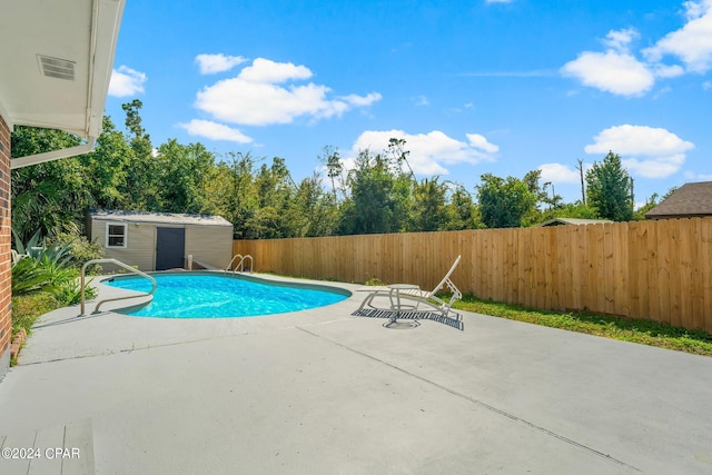 view of swimming pool featuring a patio and a storage unit