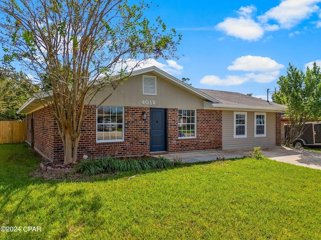 ranch-style home featuring a front lawn and a patio