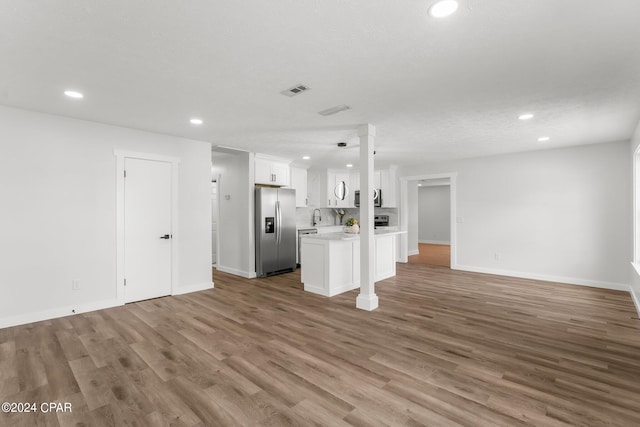 unfurnished living room with sink, wood-type flooring, and a textured ceiling