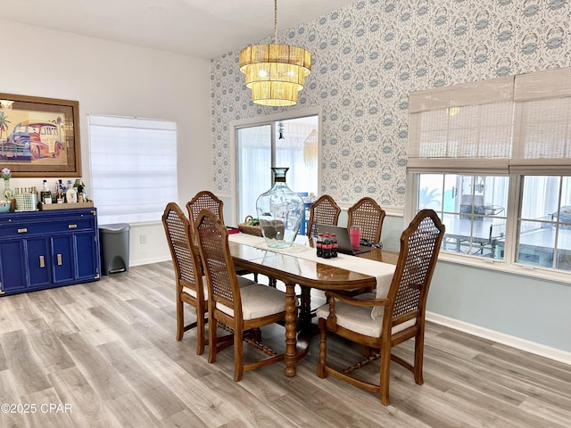 dining area with wallpapered walls, light wood-style flooring, and baseboards