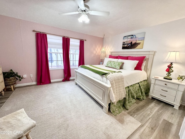 bedroom with a textured ceiling, ceiling fan, wood finished floors, and baseboards