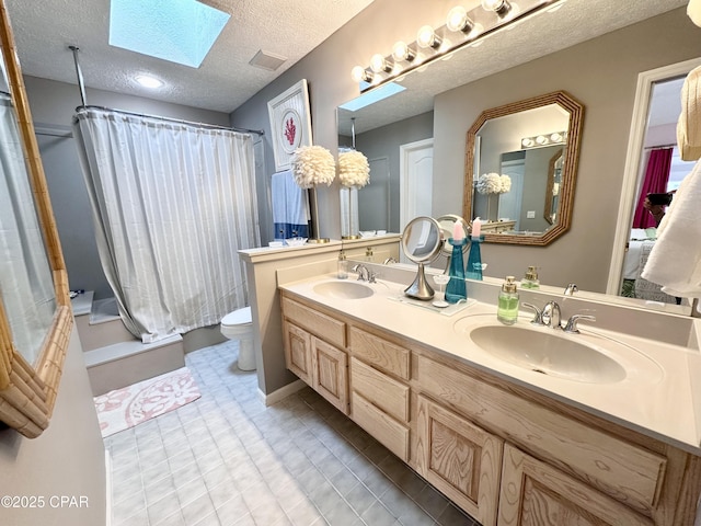 full bath with a textured ceiling, a skylight, a sink, and a shower with curtain