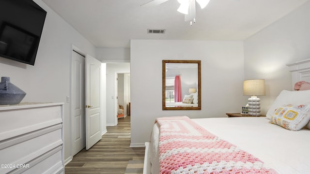 bedroom featuring wood finished floors, visible vents, and a ceiling fan