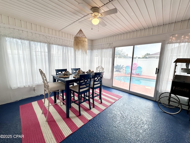 dining space featuring a ceiling fan and a sunroom